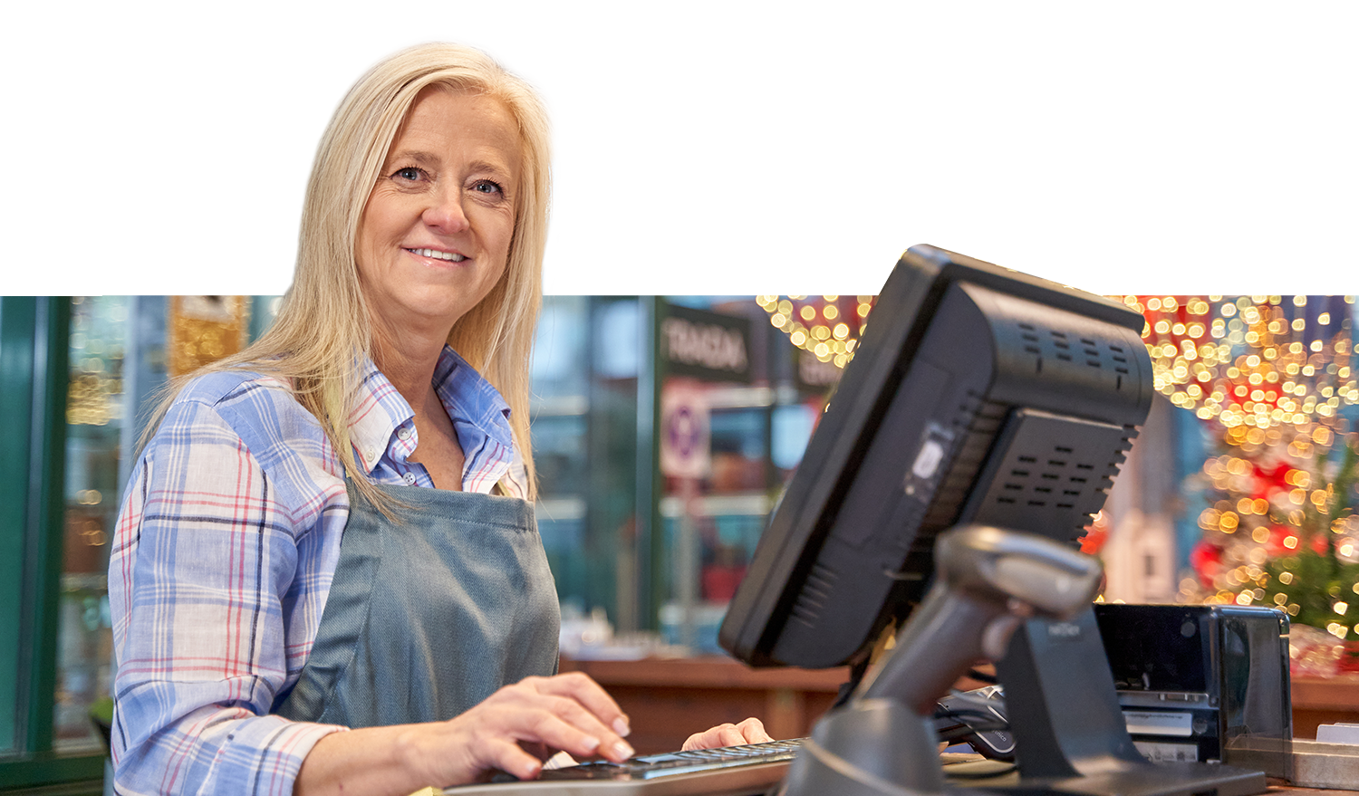 Woman shopkeeper, smiling, using POS system for business requiring CDE Lightband services