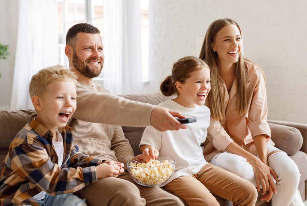 Image of family with young daughter and son, mother and father watching a movie in their living room, Clarksville, Tennessee