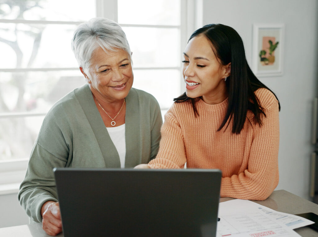 Mother and daughter navigate online web portal for account management of services