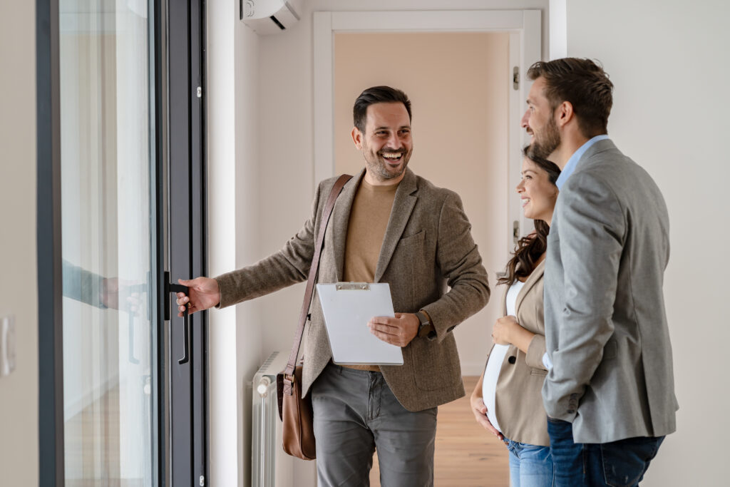 Image of landlord, smiling, and laughing, showing new tenants around a property