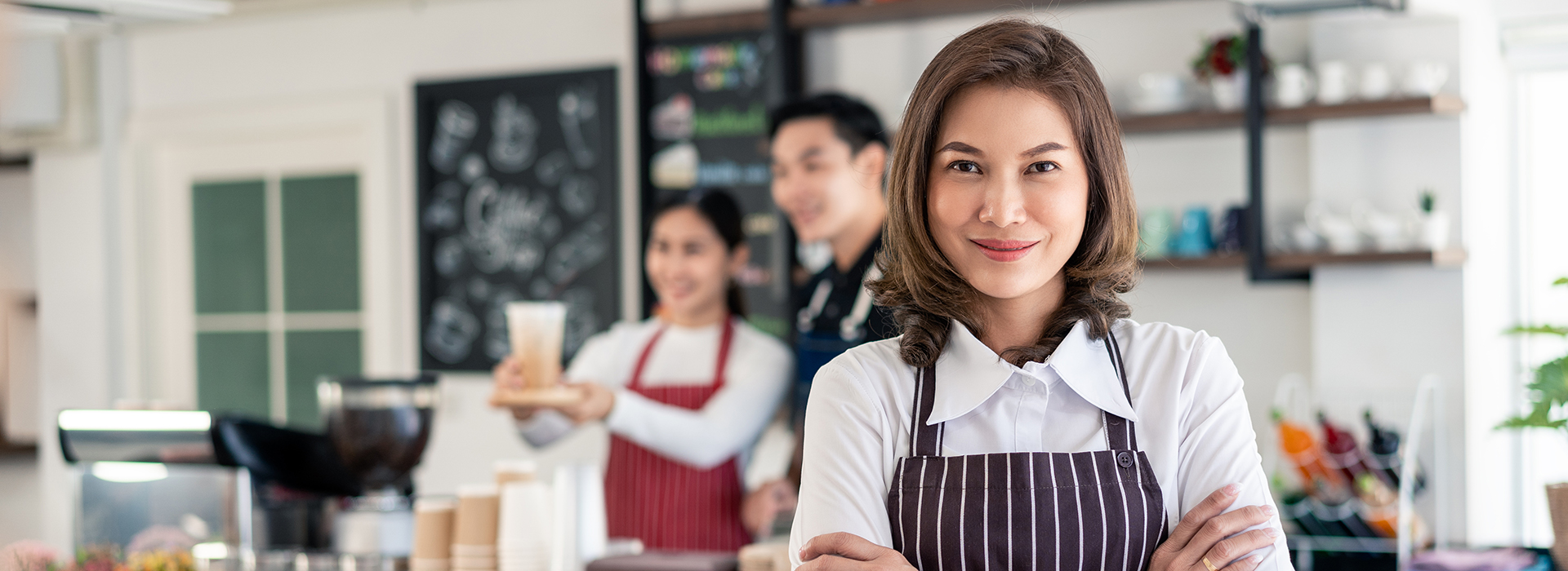 Photo of woman business owner confidently standing in her coffee shop