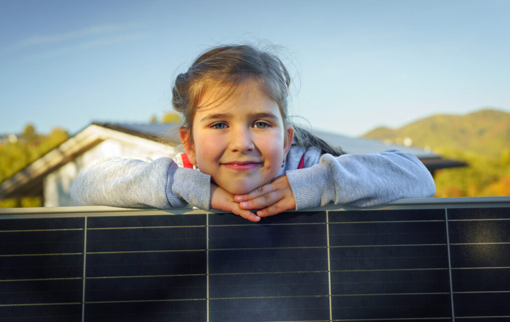 Image of little girl next to solar panel