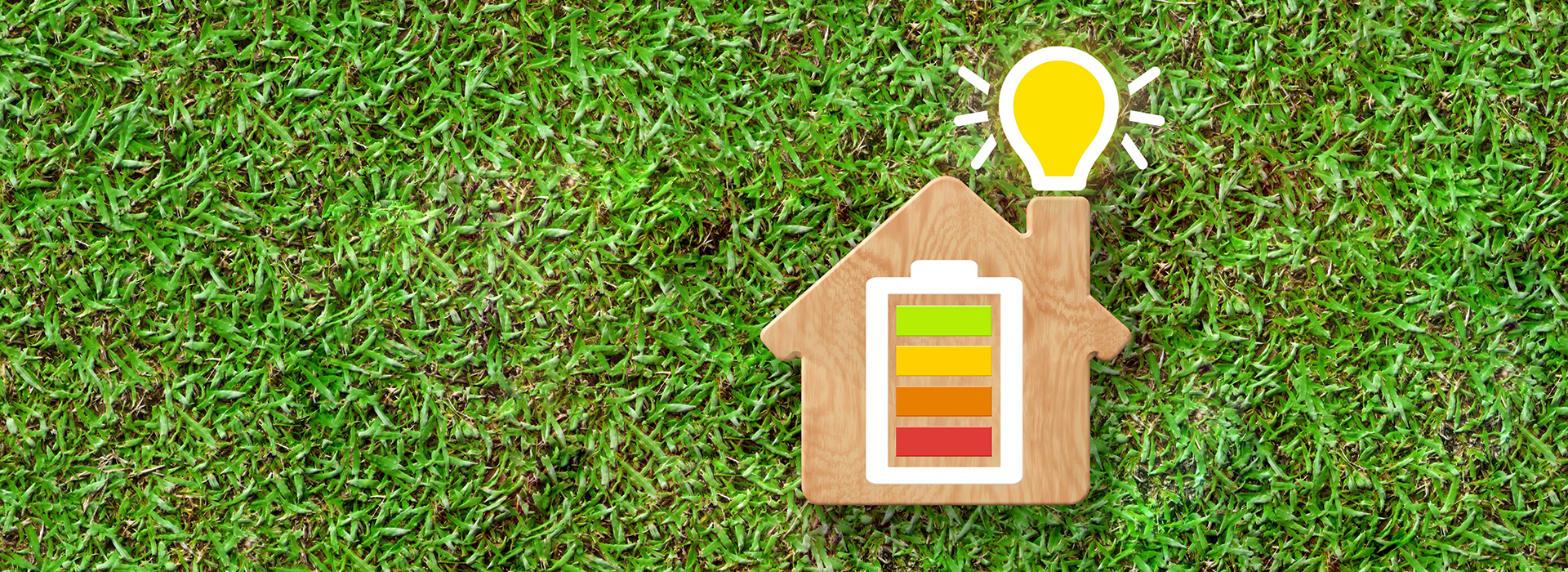 Image of spring grass with a model of a house and energy icons