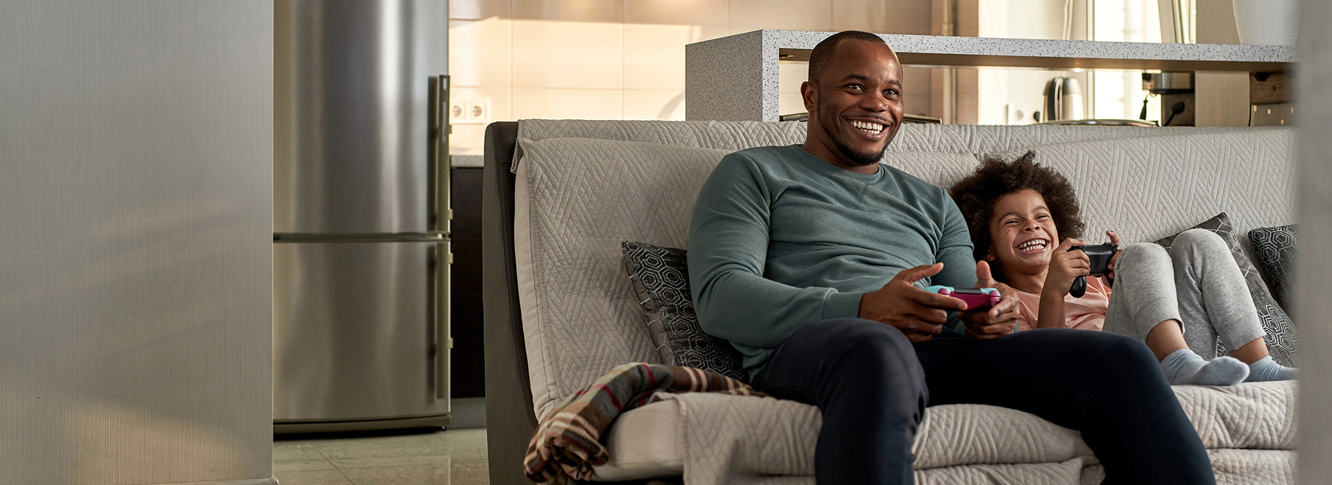 Image of father and son hanging out on the couch, relaxing and playing some video games after having CDE service transferred to their new home